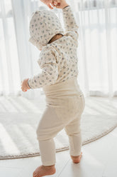 Baby wearing Avauma Aileen Baby Leggings in Butter Cream, stretchy high-waist baby pants for a snug and cozy fit.